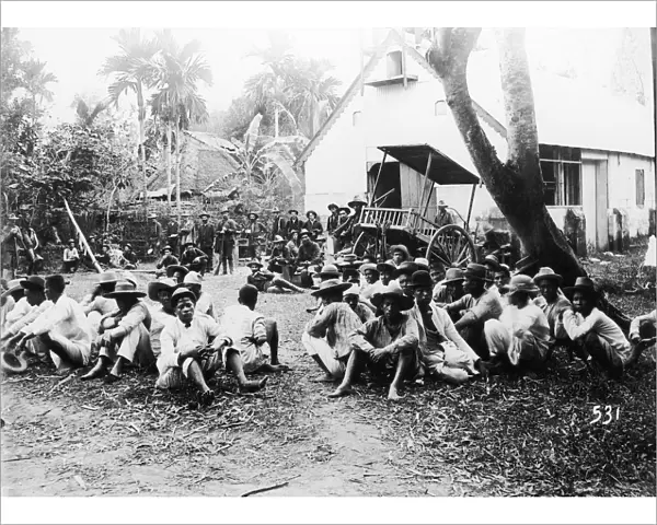 American soldiers stand guard over captured guerrillas in 1899
